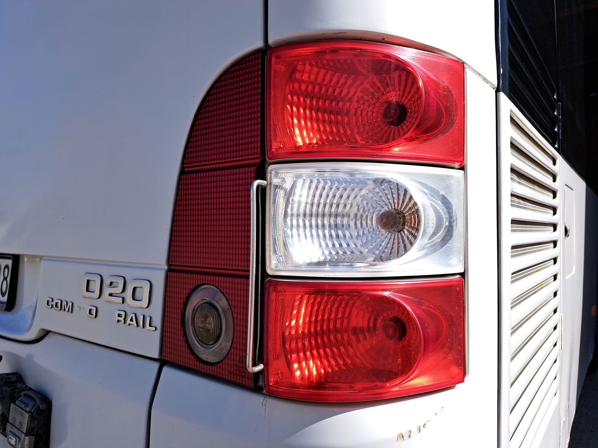 Detailaufnahme eines Busses, dessen Rücklichter aktiviert sind und rot leuchten.